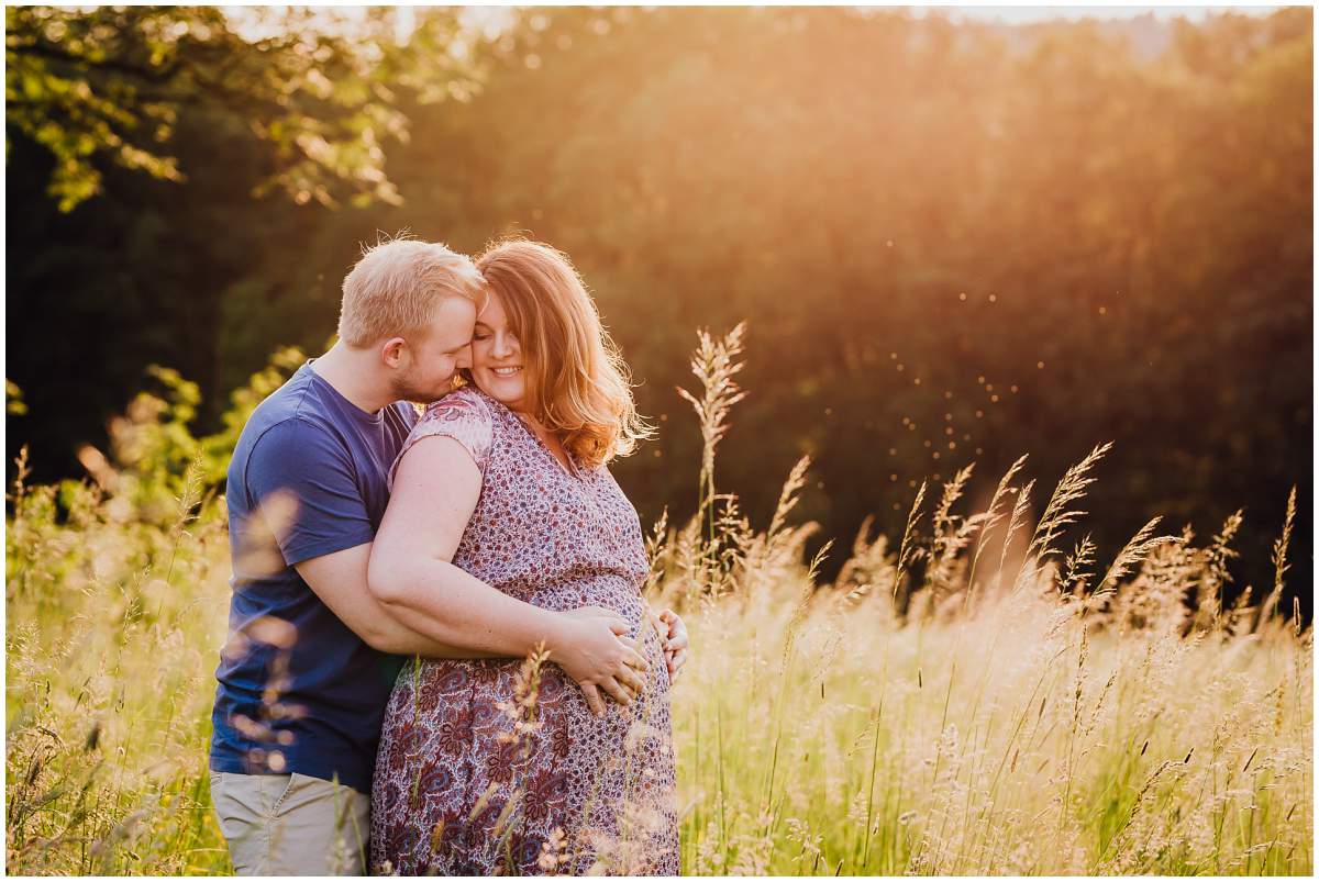 Natürliche und authentische Babybauchfotos mit Partner bei Sonnenuntergang in der freien Natur in Hattingen