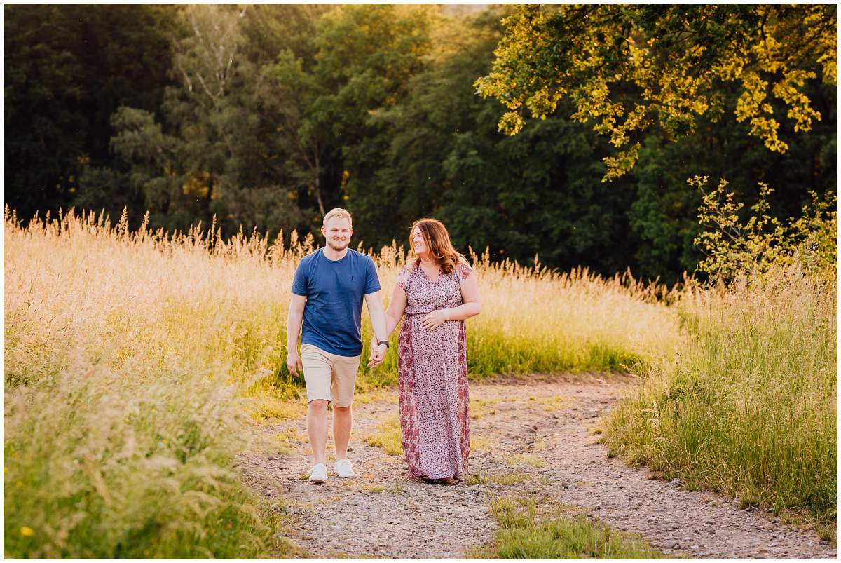 Natürliche und authentische Babybauchfotos mit Partner bei Sonnenuntergang in der freien Natur in Hattingen