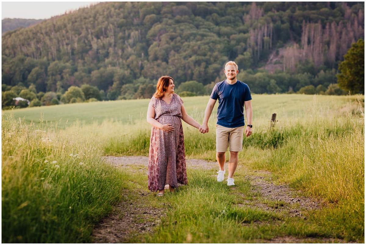 Natürliche und authentische Babybauchfotos mit Partner bei Sonnenuntergang in der freien Natur in Hattingen