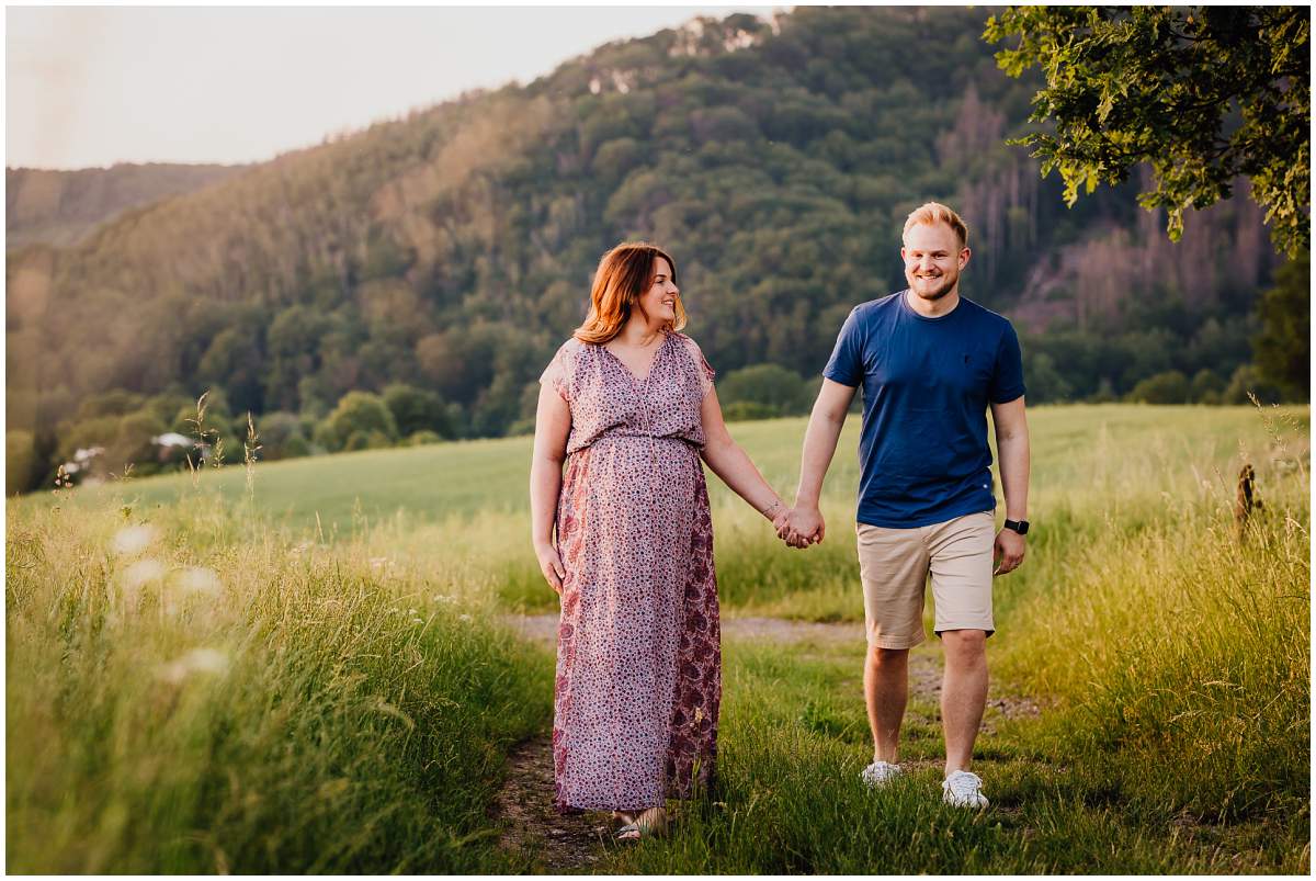 Natürliche und authentische Babybauchfotos mit Partner bei Sonnenuntergang in der freien Natur in Hattingen