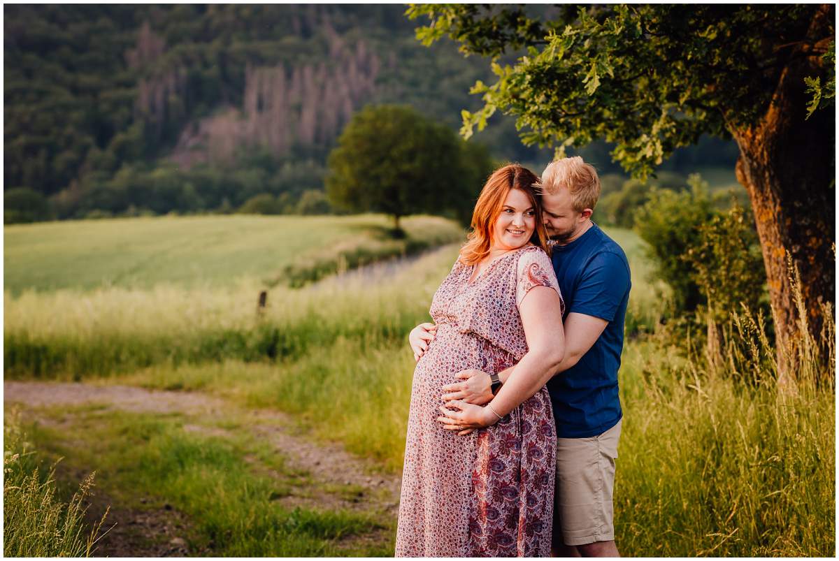 Natürliche und authentische Babybauchfotos mit Partner bei Sonnenuntergang in der freien Natur in Hattingen