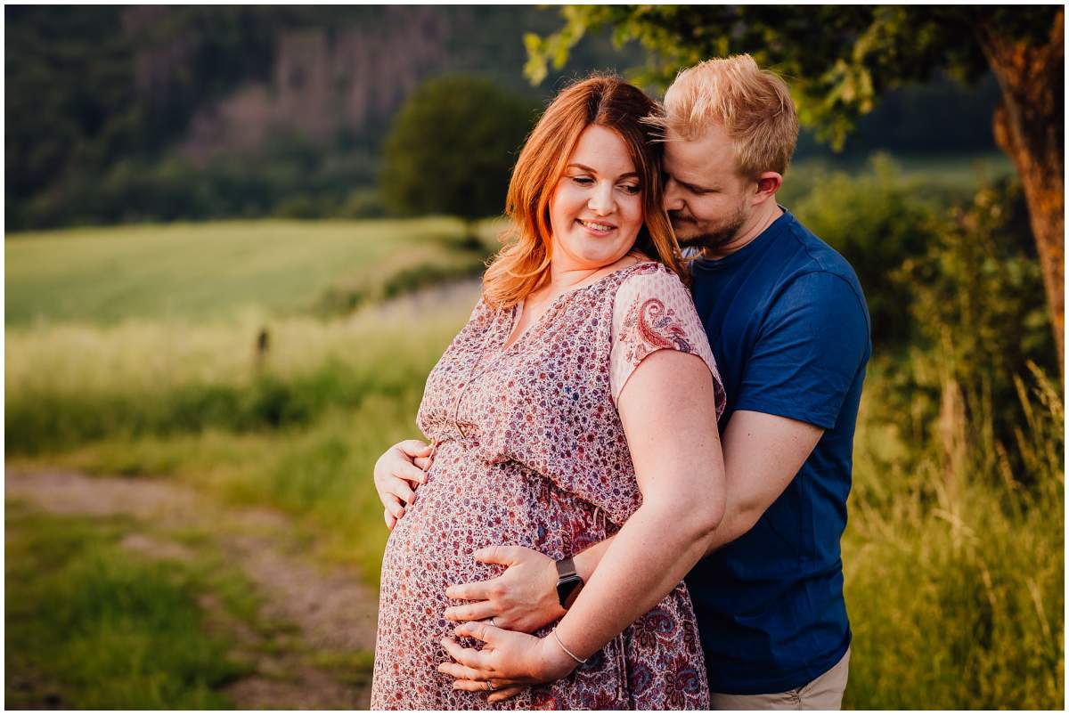 Natürliche und authentische Babybauchfotos mit Partner bei Sonnenuntergang in der freien Natur in Hattingen