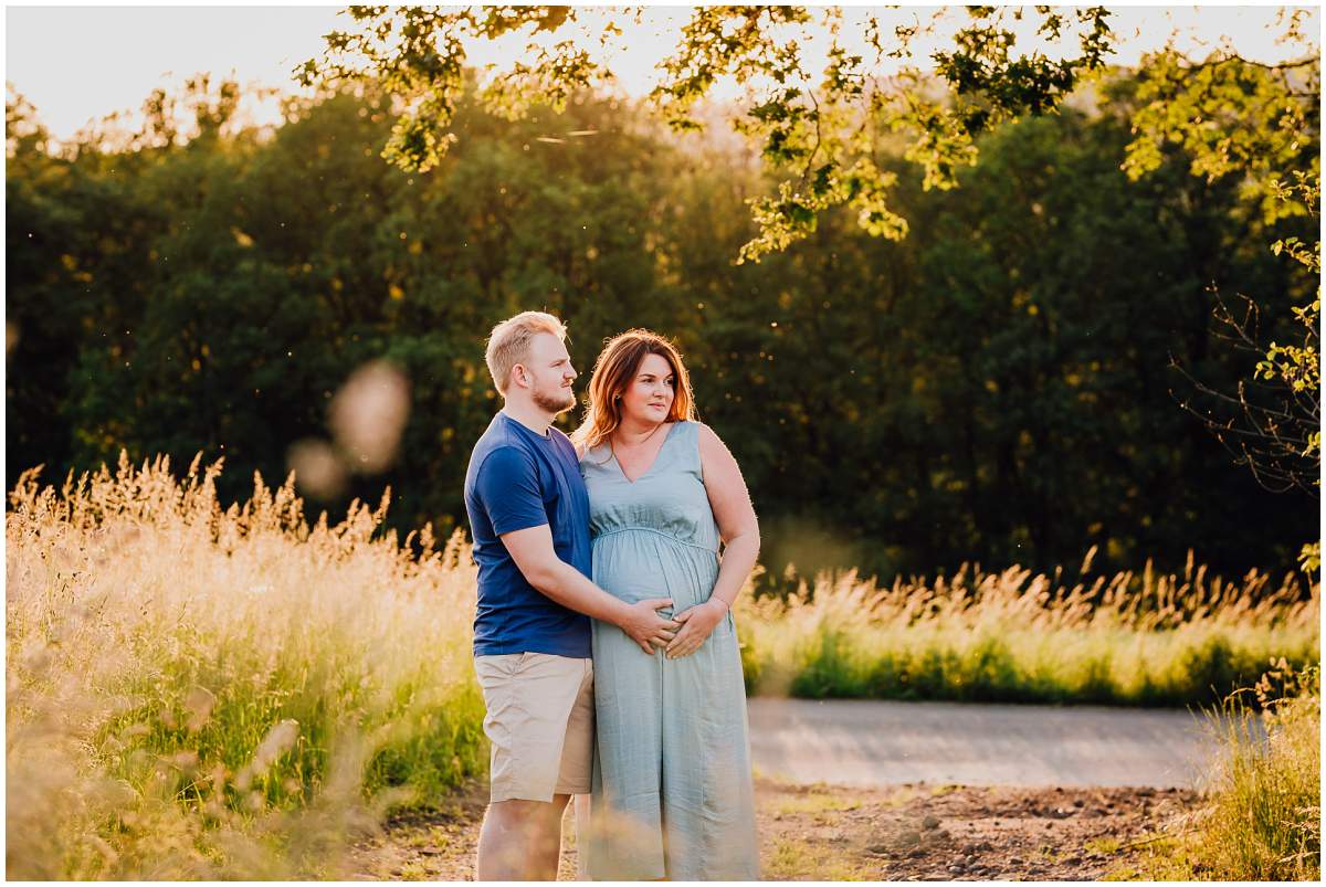 Natürliche und authentische Babybauchfotos mit Partner bei Sonnenuntergang in der freien Natur in Hattingen