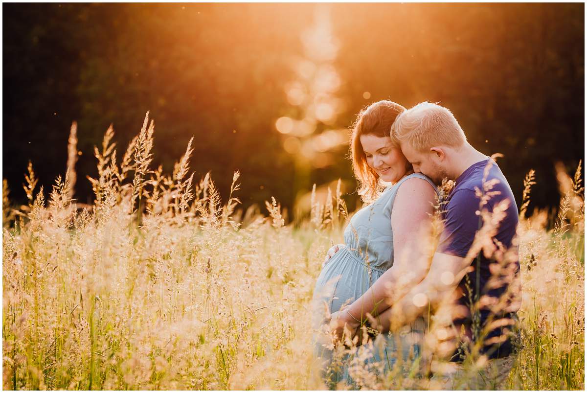 Natürliche und authentische Babybauchfotos mit Partner bei Sonnenuntergang in der freien Natur in Hattingen