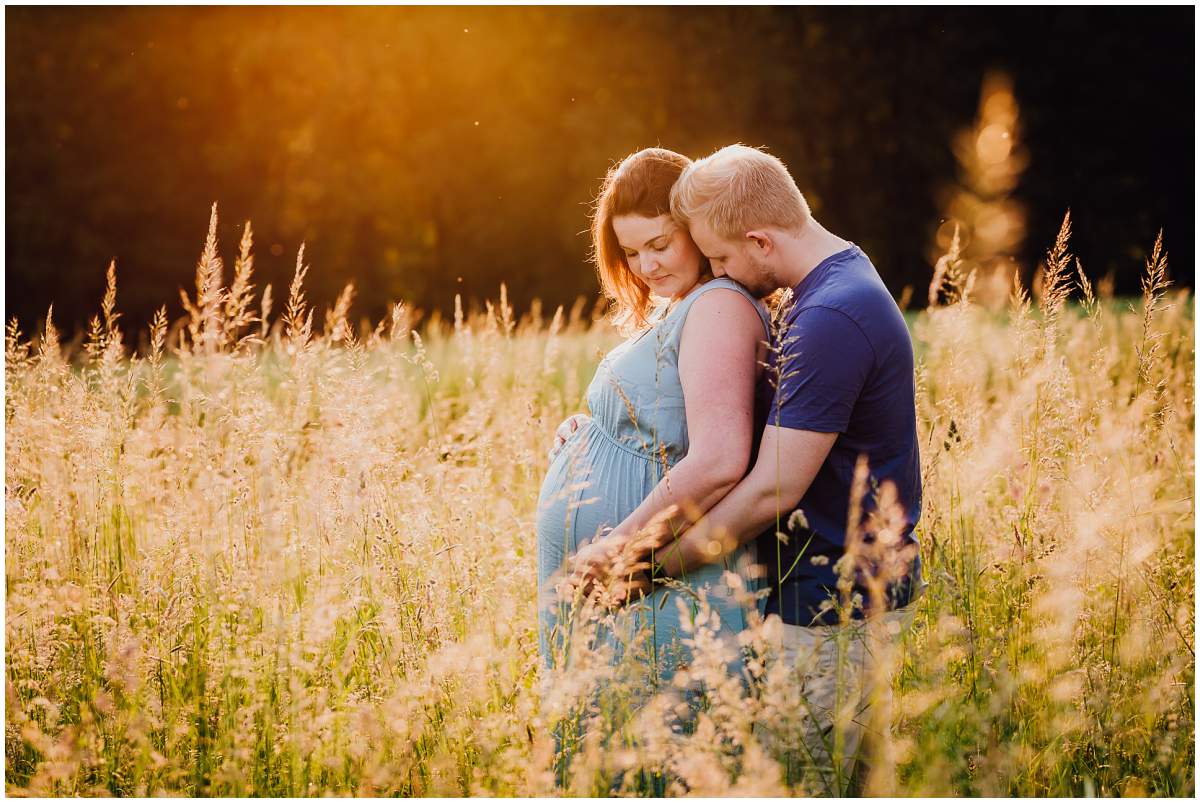 Natürliche und authentische Babybauchfotos mit Partner bei Sonnenuntergang in der freien Natur in Hattingen