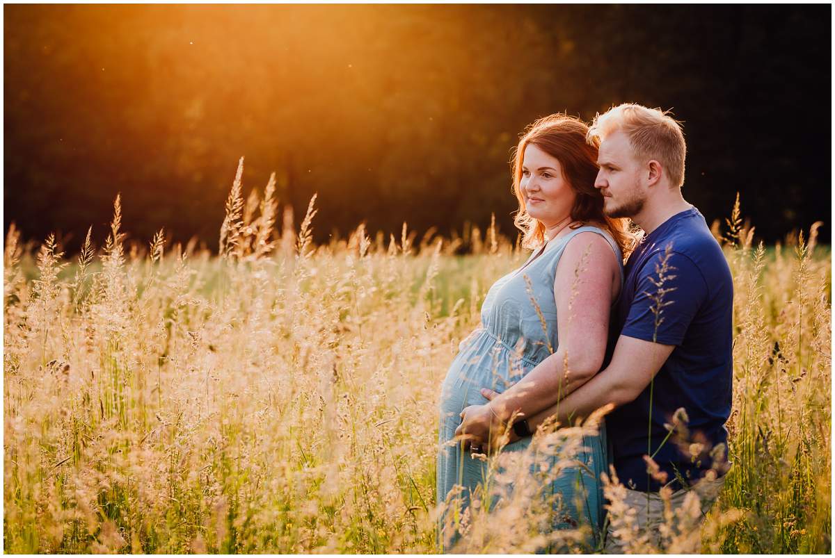 Natürliche und authentische Babybauchfotos mit Partner bei Sonnenuntergang in der freien Natur in Hattingen