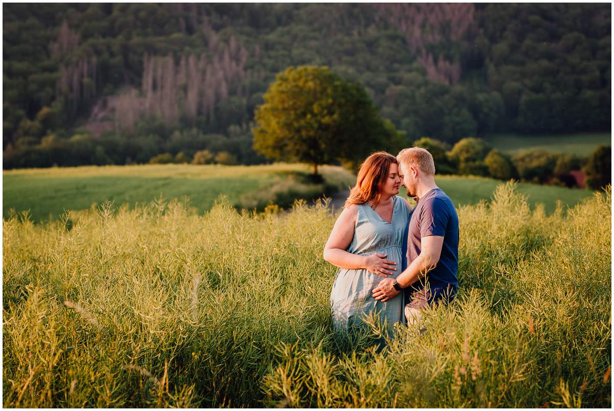 Natürliche und authentische Babybauchfotos mit Partner bei Sonnenuntergang in der freien Natur in Hattingen