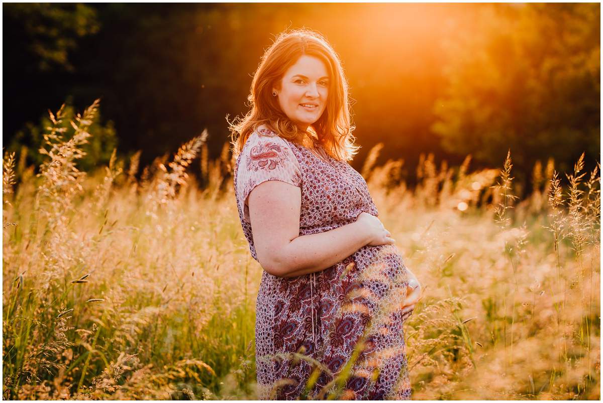 Natürliche und authentische Babybauchfotos mit Partner bei Sonnenuntergang in der freien Natur in Hattingen