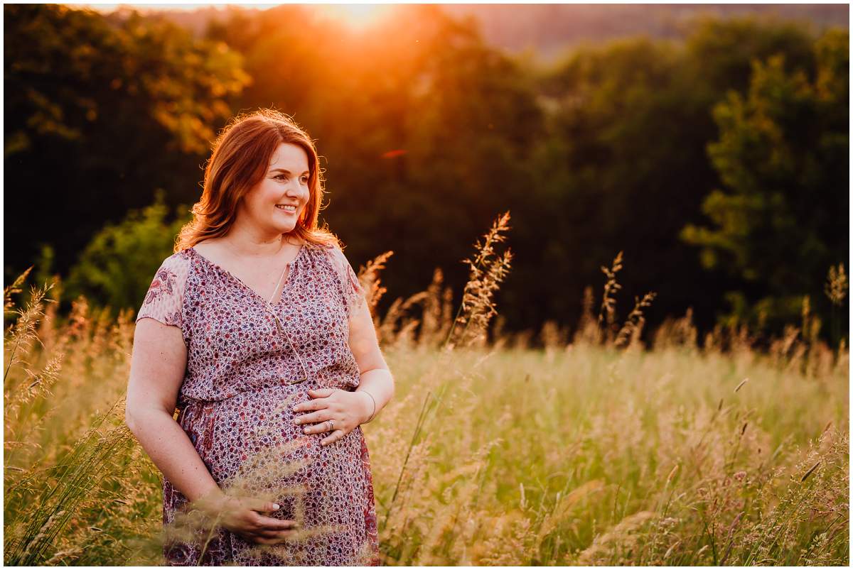 Natürliche und authentische Babybauchfotos mit Partner bei Sonnenuntergang in der freien Natur in Hattingen