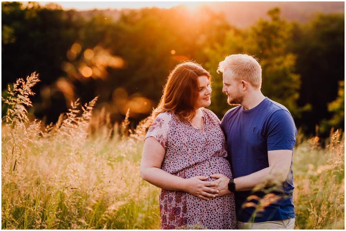 Natürliche und authentische Babybauchfotos mit Partner bei Sonnenuntergang in der freien Natur in Hattingen