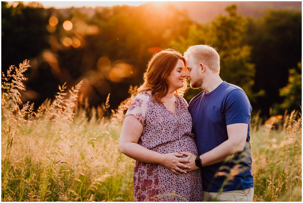 Natürliche und authentische Babybauchfotos mit Partner bei Sonnenuntergang in der freien Natur in Hattingen