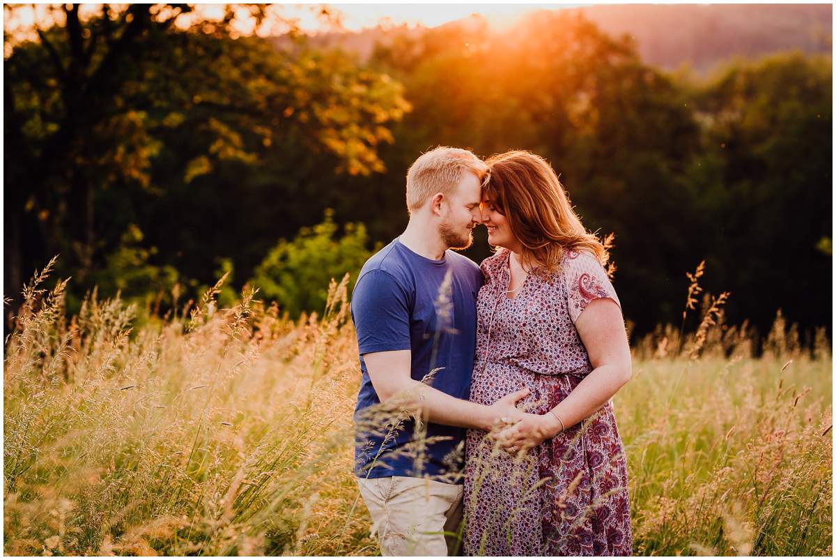 Natürliche und authentische Babybauchfotos mit Partner bei Sonnenuntergang in der freien Natur in Hattingen